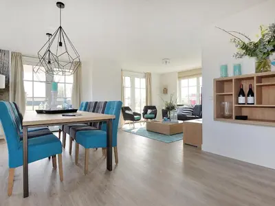 a dining room and living room with a table and chairs at Holiday Home Tapuit 8-2 by Interhome in Noordwijk