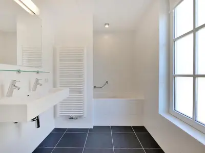 a white bathroom with a sink and a tub at Holiday Home Tapuit 8-2 by Interhome in Noordwijk