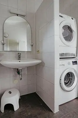 a bathroom with a washing machine and a sink at Holiday Home Kraaijennest by Interhome in Uitgeest
