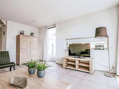 a living room with a large television and a couch at Holiday Home Dorregeest-1 by Interhome in Uitgeest