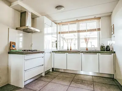 a kitchen with white cabinets and a window at Holiday Home Dorregeest-1 by Interhome in Uitgeest