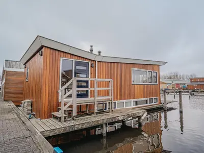 a house on a dock on a body of water at Holiday Home De Woude by Interhome in Uitgeest