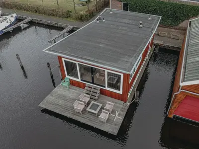 a small house on a dock in the water at Holiday Home De Woude by Interhome in Uitgeest