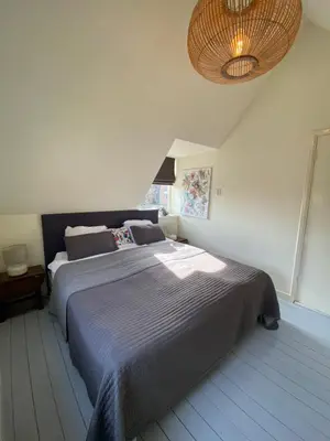 a bedroom with a large bed with a blue blanket at Tiny House De Oude Berg in Bergen