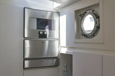 a kitchen with a stainless steel refrigerator and a mirror at Luxurious 110m² 3br Houseboat in Amsterdam Centre! in Amsterdam