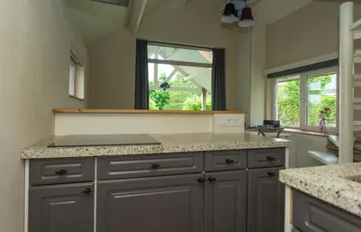a kitchen with a counter top and a window at Klein Polderhuis - tuinhuis in Roelofarendsveen