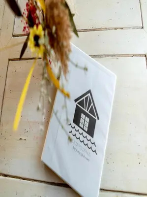 a white envelope sitting on top of a table with flowers at Klein Polderhuis - tuinhuis in Roelofarendsveen