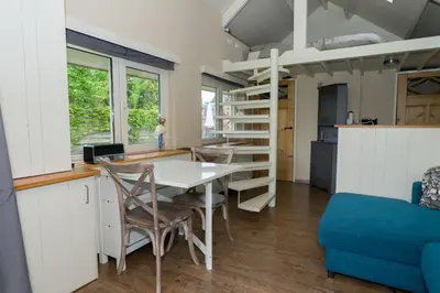 a room with a table and chairs and a bunk bed at Klein Polderhuis - tuinhuis in Roelofarendsveen