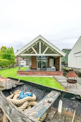 a house with a boat in front of it at Klein Polderhuis - tuinhuis in Roelofarendsveen
