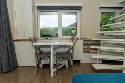 a table and two chairs in a room with a window at Klein Polderhuis - tuinhuis in Roelofarendsveen