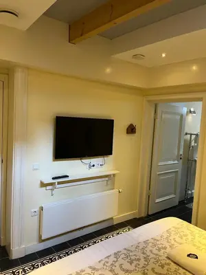 a bedroom with a flat screen tv on the wall at De Verrassing in Utrecht