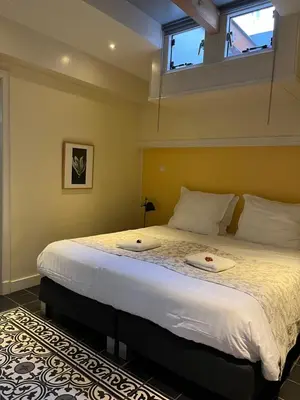 a bedroom with a large bed with a window at De Verrassing in Utrecht