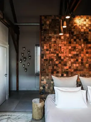 a bedroom with a bed and a brick wall at Boutiquehotel Staats in Haarlem