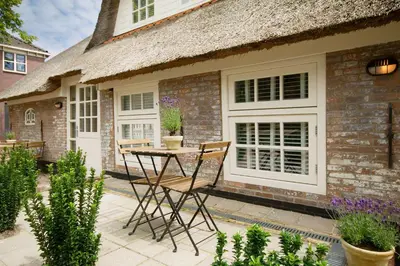 a patio with a table and chairs in front of a house at 