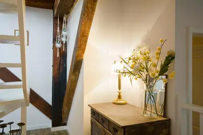 a vase of flowers on a wooden table in a hallway at 