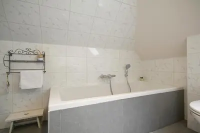 a white bathroom with a tub and a toilet at 