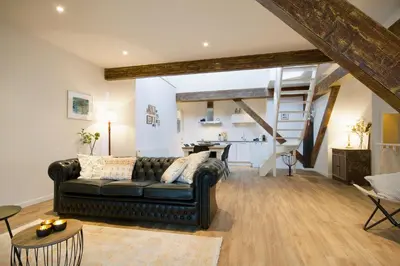 a living room with a black leather couch and a kitchen at 