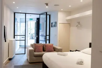 a hotel room with a bed and a couch at Spui apartment in center in Amsterdam