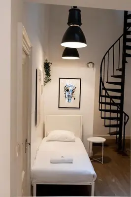 a small room with a bed and a staircase at Spui apartment in center in Amsterdam