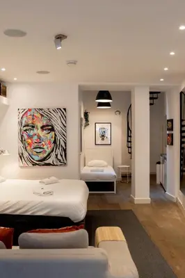 a room with two beds and a painting on the wall at Spui apartment in center in Amsterdam