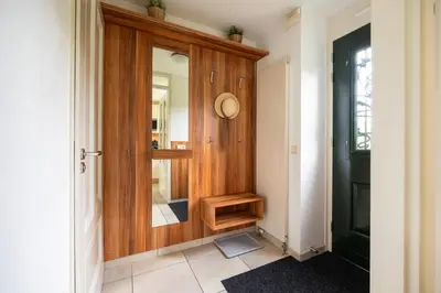 a hallway with a wooden door with a mirror at Ferienhaus Sonnenschein in Sint Maarten