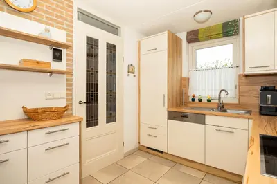 a kitchen with white cabinets and a sink and a window at Ferienhaus Sonnenschein in Sint Maarten