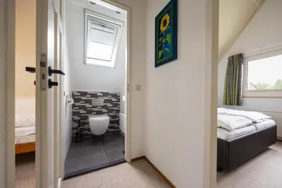 a bathroom with a bed and a toilet in a room at Ferienhaus Sonnenschein in Sint Maarten