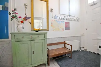 a green dresser with a mirror and a bench in a room at Cozy Jordaan canalhouse near Anne Frank House in Amsterdam