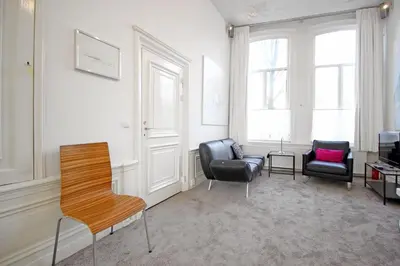 a living room with two chairs and a table at Cozy Jordaan canalhouse near Anne Frank House in Amsterdam