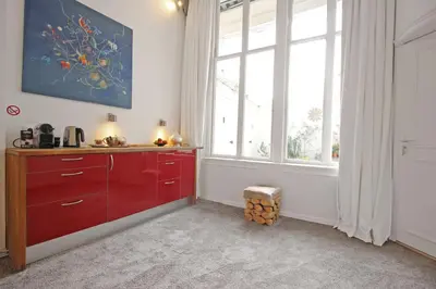 a kitchen with red cabinets and a large window at Cozy Jordaan canalhouse near Anne Frank House in Amsterdam