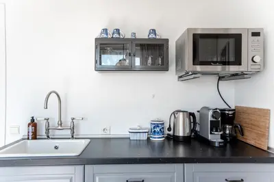 a kitchen with a sink and a microwave at Villa 't Spokeduin in Zandvoort