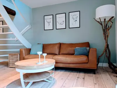 a living room with a couch and a table at Duinkant in Groet