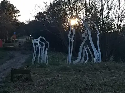a group ofulptured trees in a field at night at Duinkant in Groet