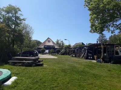 a yard with a barn and a field of grass at Duinkant in Groet