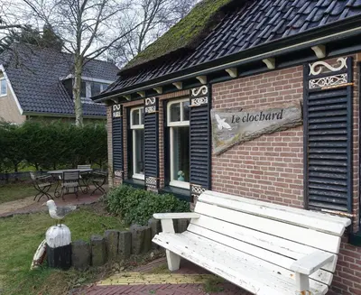 a wooden bench in front of a building at Duinkant in Groet