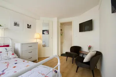 a bedroom with a bed and two chairs and a desk at Spui's the Limit in Amsterdam