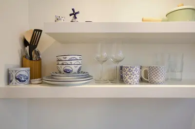 a shelf with plates and wine glasses on it at Spui's the Limit in Amsterdam