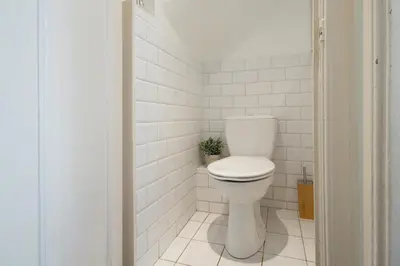 a white toilet in a bathroom with white tiles at Spui's the Limit in Amsterdam
