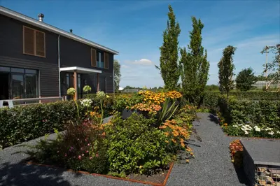 a garden in front of a house at als het golft in Roelofarendsveen