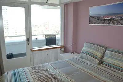 a bedroom with a bed and a window with a view at Beach Apartment Ikusasa in Zandvoort
