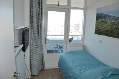 a bedroom with a bed and a window with a view at Beach Apartment Ikusasa in Zandvoort