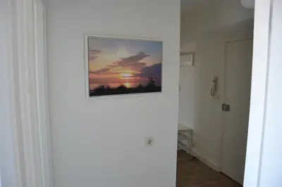 a picture of a sunset on the wall of a hallway at Beach Apartment Ikusasa in Zandvoort
