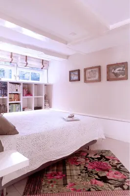 a white bedroom with a large bed and a rug at Cozy Canal Studio in Amsterdam