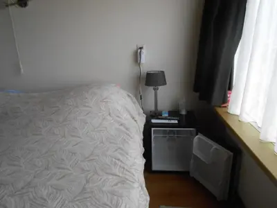 a bedroom with a bed and a table with a lamp at Hetem's Room in Amsterdam