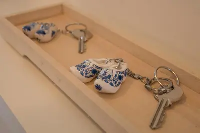 three pairs of tea cups and a pair of keys at Amsterdam Beach Apartment 80 in Zandvoort