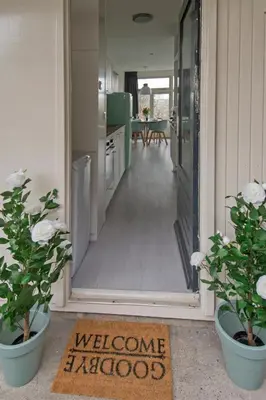 a doorway into a kitchen with two potted plants at Amsterdam Beach Apartment 80 in Zandvoort