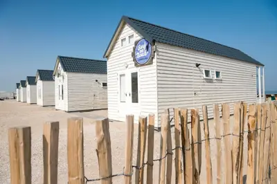 a building with a clock on the side of it at Surf en beach strandhuisjes in Katwijk