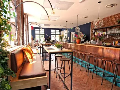 a bar with wooden tables and stools in a restaurant at Chasse Boutique Hotel in Amsterdam
