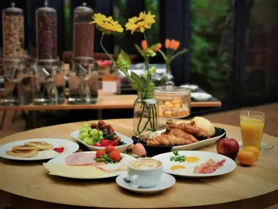 a table topped with plates of food and cups of coffee at Chasse Boutique Hotel in Amsterdam