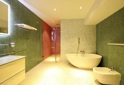 a bathroom with a tub and a toilet and a sink at Chasse Boutique Hotel in Amsterdam